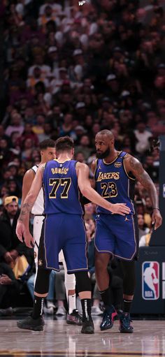 two basketball players standing next to each other on a court