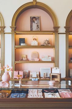 a display case filled with pink and gold items