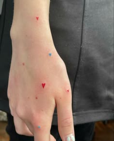 a person's hand with small red and blue dots on the thumbnails