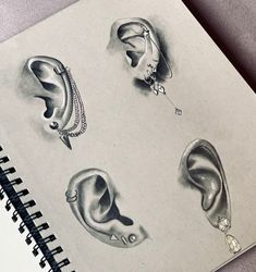 pencil drawing of ear, nose, and headphones on top of a spiral notebook