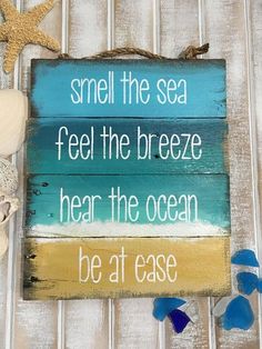 a wooden sign that says smell the sea feel the breeze hear the ocean be at ease