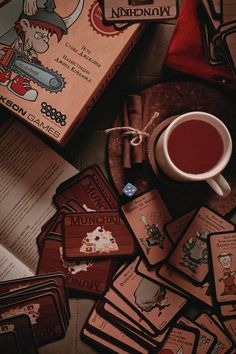 a table topped with lots of cards next to a cup of coffee