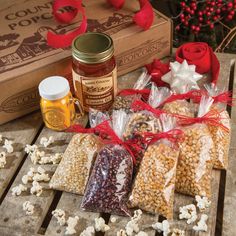 popcorn, nuts and other items are on a table next to a box with red roses