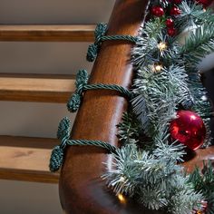 the christmas tree is decorated with red and green ornaments on it's wooden sleigh