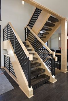 a wooden staircase with black railings in a house