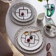 the table is set with plates, cups, and vases on top of it