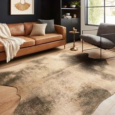 a living room filled with furniture and a rug on top of a hard wood floor