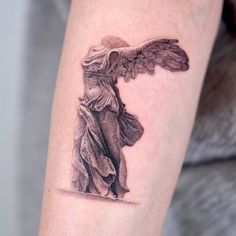 a woman's arm with an angel tattoo on the left side of her body