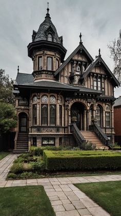 an old victorian style house in the middle of a garden