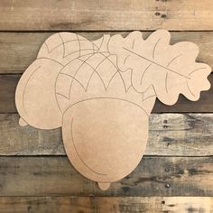 a cutout of acorns and leaves on a wooden background