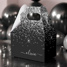 a black and white box with silver confetti on it