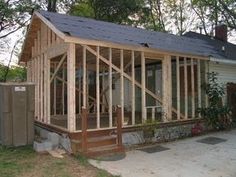 a house being built in the yard with wood framing on it's roof and windows