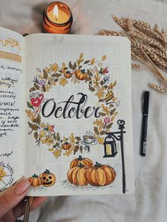 a hand holding an open book with the words october written on it and pumpkins