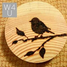 a wooden button with a bird sitting on a branch