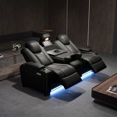 a black leather reclining sofa sitting on top of a gray carpeted floor next to a coffee table