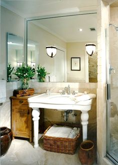 a white sink sitting under a bathroom mirror