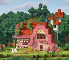 a pink house in the middle of a lush green forest