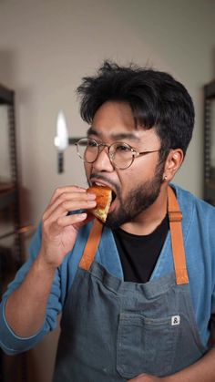 a man in an apron eating a sandwich