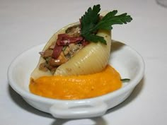 a white bowl filled with food and garnished with green leafy garnish