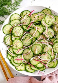 a white bowl filled with cucumbers and onions