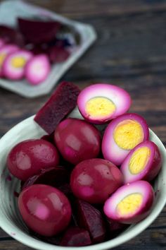 a bowl filled with beets on top of a wooden table