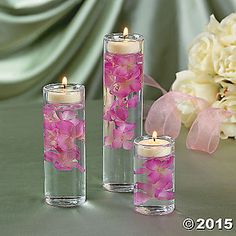 three glass vases with pink flowers in them