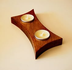 two candles are sitting on a wooden stand