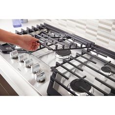 a person is reaching for something on the stove top that's being used as an appliance