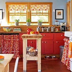 a kitchen with red cabinets and an island in front of the stove top oven is shown