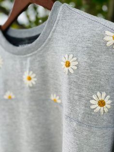 a grey sweatshirt with white daisies on it