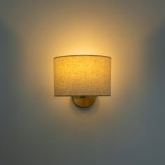 a lamp that is on the wall with a light shade over it's head