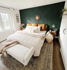 a large bed sitting on top of a wooden floor next to a green painted wall