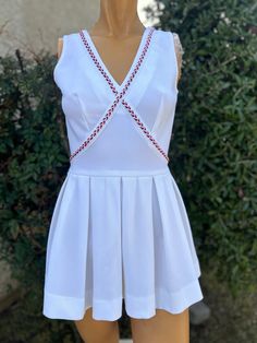 Here is a vintage 1970s white Polyester Tennis Dress.Made by Jay Dee of California .Following are the measurements. Bust 34",Waist 28",Hips full,Length measured from top of shoulder to hem 28".Zips up the back.White polyester fabric .Bodice has a crisscross design with red ,white and blue trim.Skirt has pleats.In very nice vintage condition. Please take special consideration of measurements. 1970 sizing was much smaller than today's standards. Take extra special note of length. Tennis dresss wer Vintage Tennis Dress, Vintage Tennis, Womens Sports, Blue Trim, Tennis Dress, Vintage 1970s, Red White And Blue, Criss Cross, Sports Women