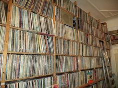 a large collection of records are stacked on the wall