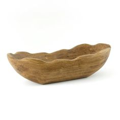 a wooden bowl sitting on top of a white table