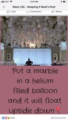 someone is sitting in the middle of a room with balloons hanging from the ceiling