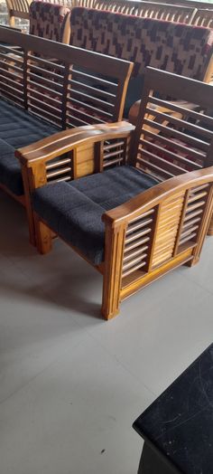 three wooden benches sitting next to each other in a room with black tile flooring