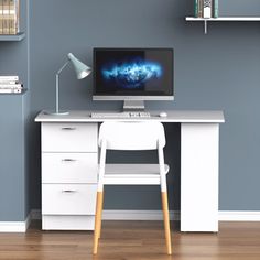 a white desk with a computer on top of it in front of bookshelves