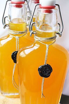 two glass bottles filled with liquid sitting on top of a table