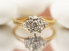 a diamond ring sitting on top of a white flower