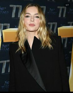 a woman standing in front of a wall with the words tiff awards on it