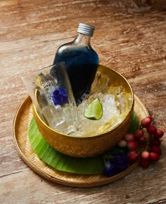 a bottle of alcohol sitting on top of a bowl filled with ice and garnish