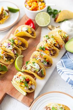 several tacos are lined up on a cutting board