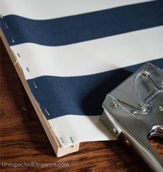 a piece of luggage sitting on top of a wooden floor next to a blue and white striped wall