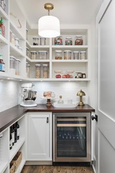 a kitchen with white cabinets and wood flooring is pictured in this image, the oven has been built into the wall