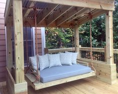 a porch swing bed with pillows on it