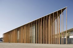 the building has wooden slats on it's sides and is next to a parking lot