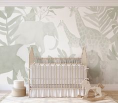 a baby's room with an elephant and giraffe wallpaper