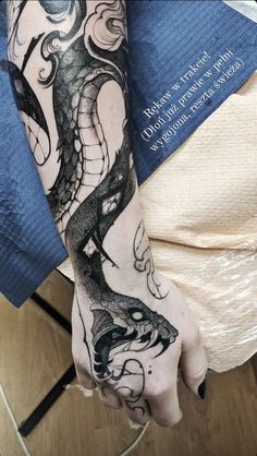 a woman's arm with a dragon tattoo on it