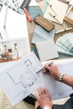 a woman is working on some architectural drawings